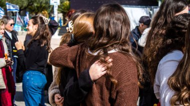 Tel Aviv, İsrail - 25 Ocak 2024 İsrailli gençler Tel Aviv 'deki Rehine Meydanı' nda hala Gazze 'de tutulan 100 rehinenin anısına şarkı söylüyorlar. İnsanlar düzenli olarak rehine ailelerini desteklemek için toplanır.