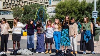 Tel Aviv, İsrail - 25 Ocak 2024 İsrailli gençler Tel Aviv 'deki Rehine Meydanı' nda hala Gazze 'de tutulan 100 rehinenin anısına şarkı söylüyorlar. İnsanlar düzenli olarak rehine ailelerini desteklemek için toplanır.