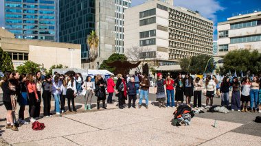 Tel Aviv, İsrail - 25 Ocak 2024 İsrailli gençler Tel Aviv 'deki Rehine Meydanı' nda hala Gazze 'de tutulan 100 rehinenin anısına şarkı söylüyorlar. İnsanlar düzenli olarak rehine ailelerini desteklemek için toplanır.