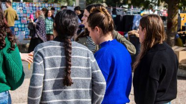 Tel Aviv, İsrail - 25 Ocak 2024 İsrailli gençler Tel Aviv 'deki Rehine Meydanı' nda hala Gazze 'de tutulan 100 rehinenin anısına şarkı söylüyorlar. İnsanlar düzenli olarak rehine ailelerini desteklemek için toplanır.