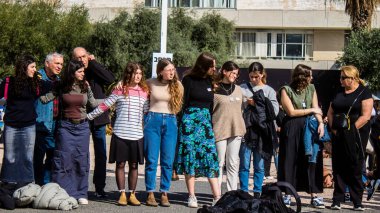 Tel Aviv, İsrail - 25 Ocak 2024 İsrailli gençler Tel Aviv 'deki Rehine Meydanı' nda hala Gazze 'de tutulan 100 rehinenin anısına şarkı söylüyorlar. İnsanlar düzenli olarak rehine ailelerini desteklemek için toplanır.