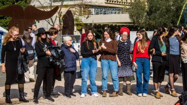 Tel Aviv, İsrail - 25 Ocak 2024 İsrailli gençler Tel Aviv 'deki Rehine Meydanı' nda hala Gazze 'de tutulan 100 rehinenin anısına şarkı söylüyorlar. İnsanlar düzenli olarak rehine ailelerini desteklemek için toplanır.