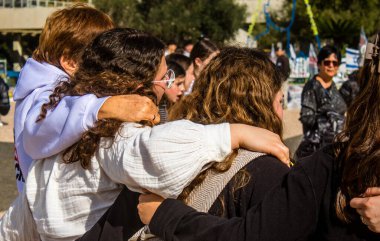 Tel Aviv, İsrail - 25 Ocak 2024 İsrailli gençler Tel Aviv 'deki Rehine Meydanı' nda hala Gazze 'de tutulan 100 rehinenin anısına şarkı söylüyorlar. İnsanlar düzenli olarak rehine ailelerini desteklemek için toplanır.