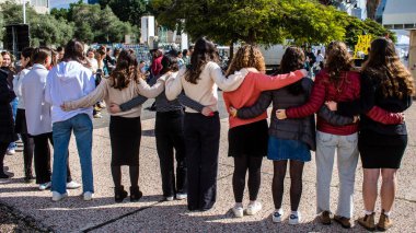 Tel Aviv, İsrail - 25 Ocak 2024 İsrailli gençler Tel Aviv 'deki Rehine Meydanı' nda hala Gazze 'de tutulan 100 rehinenin anısına şarkı söylüyorlar. İnsanlar düzenli olarak rehine ailelerini desteklemek için toplanır.