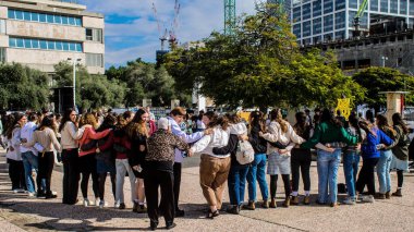 Tel Aviv, İsrail - 25 Ocak 2024 İsrailli gençler Tel Aviv 'deki Rehine Meydanı' nda hala Gazze 'de tutulan 100 rehinenin anısına şarkı söylüyorlar. İnsanlar düzenli olarak rehine ailelerini desteklemek için toplanır.