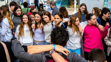 Tel Aviv, İsrail - 9 Ocak 2024 İsrailli gençler Tel Aviv 'deki Rehine Meydanı' nda hala Gazze 'de tutulan 129 rehinenin anısına şarkı söylüyorlar. İnsanlar düzenli olarak rehine ailelerini desteklemek için toplanır.