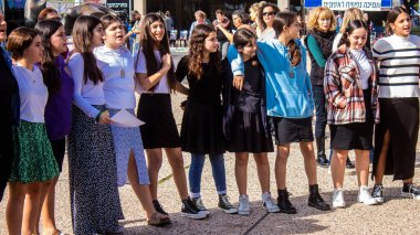 Tel Aviv, İsrail - 4 Ocak 2024 İsrailli gençler Tel Aviv 'deki Rehine Meydanı' nda hala Gazze 'de tutulan 129 rehinenin anısına şarkı söylüyorlar. İnsanlar düzenli olarak rehine ailelerini desteklemek için toplanır.