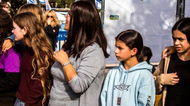 Tel Aviv, İsrail - 4 Ocak 2024 İsrailli gençler Tel Aviv 'deki Rehine Meydanı' nda hala Gazze 'de tutulan 129 rehinenin anısına şarkı söylüyorlar. İnsanlar düzenli olarak rehine ailelerini desteklemek için toplanır.