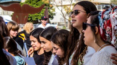 Tel Aviv, İsrail - 4 Ocak 2024 İsrailli gençler Tel Aviv 'deki Rehine Meydanı' nda hala Gazze 'de tutulan 129 rehinenin anısına şarkı söylüyorlar. İnsanlar düzenli olarak rehine ailelerini desteklemek için toplanır.