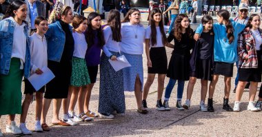 Tel Aviv, İsrail - 4 Ocak 2024 İsrailli gençler Tel Aviv 'deki Rehine Meydanı' nda hala Gazze 'de tutulan 129 rehinenin anısına şarkı söylüyorlar. İnsanlar düzenli olarak rehine ailelerini desteklemek için toplanır.