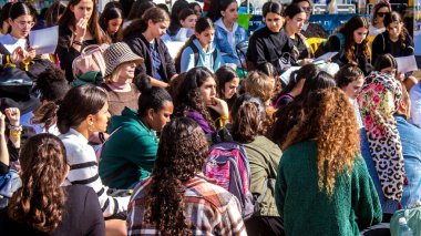 Tel Aviv, İsrail - 4 Ocak 2024 İsrailli gençler Tel Aviv 'deki Rehine Meydanı' nda hala Gazze 'de tutulan 129 rehinenin anısına şarkı söylüyorlar. İnsanlar düzenli olarak rehine ailelerini desteklemek için toplanır.