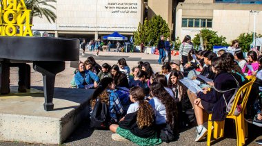 Tel Aviv, İsrail - 4 Ocak 2024 İsrailli gençler Tel Aviv 'deki Rehine Meydanı' nda hala Gazze 'de tutulan 129 rehinenin anısına şarkı söylüyorlar. İnsanlar düzenli olarak rehine ailelerini desteklemek için toplanır.