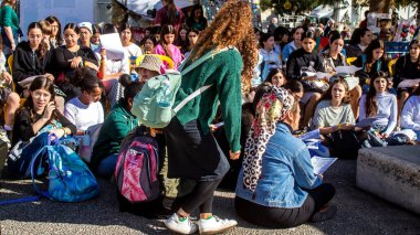 Tel Aviv, İsrail - 4 Ocak 2024 İsrailli gençler Tel Aviv 'deki Rehine Meydanı' nda hala Gazze 'de tutulan 129 rehinenin anısına şarkı söylüyorlar. İnsanlar düzenli olarak rehine ailelerini desteklemek için toplanır.