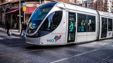 Kudüs, İsrail - 22 Aralık 2023 Modern elektrikli tramvay İsrail 'de Kudüs sokaklarında ilerliyor.