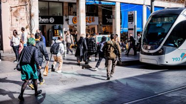 Kudüs, İsrail - 22 Aralık 2023 Modern elektrikli tramvay İsrail 'de Kudüs sokaklarında ilerliyor.