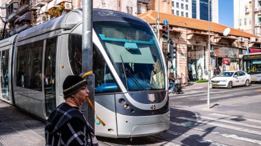 Kudüs, İsrail - 22 Aralık 2023 Modern elektrikli tramvay İsrail 'de Kudüs sokaklarında ilerliyor.