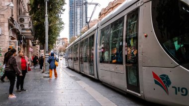 Kudüs, İsrail - 22 Aralık 2023 Modern elektrikli tramvay İsrail 'de Kudüs sokaklarında ilerliyor.