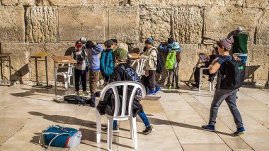 Kudüs, İsrail 26 Aralık 2023. Genç çocuklar Batı Duvarı 'nda namaz kılmaya geliyorlar. İsrail Hamas 'la savaşta olmasına rağmen insanlar kutsal bir yer olan Kotel' e gelmeye devam ediyor.