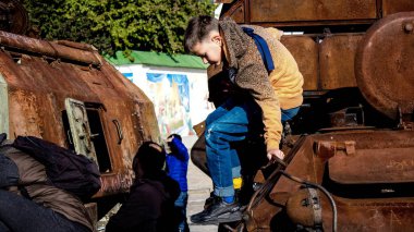 Ukraynalı çocuklar imha edilmiş Rus askeri teçhizatıyla eğleniyorlar, burayı oyun alanı olarak kullanıyorlar. Yok edilen Rus askeri teçhizat sergisi açık hava sergisi..
