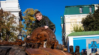 Ukraynalı çocuklar imha edilmiş Rus askeri teçhizatıyla eğleniyorlar, burayı oyun alanı olarak kullanıyorlar. Yok edilen Rus askeri teçhizat sergisi açık hava sergisi..