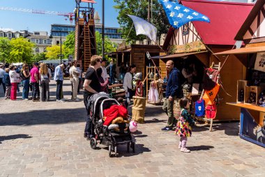 Reims, Fransa, 25 Mayıs 2024 Johanniques şenlikleri sırasında ortaçağ pazarında gezinen ziyaretçiler, Festival, Reims 'i İngilizceden kurtaran Joan of Arc' a saygılarını sunuyor.