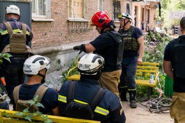 Kharkiv, Ukrayna, 01 Haziran 2024 İtfaiyeciler ve acil durum ekipleri Kharkiv 'de yıkılmış bir binanın yakınında dinleniyorlar.