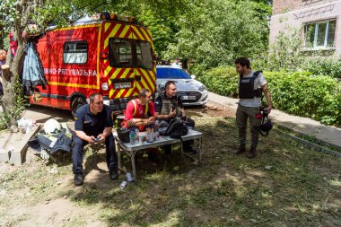 Kharkiv, Ukrayna, 01 Haziran 2024 İtfaiyeciler ve acil durum ekipleri Kharkiv 'de yıkılmış bir binanın yakınında dinleniyorlar.