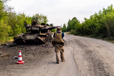Kharkiv, Ukrayna 'nın ön cephesinde, 2 Haziran 2024' te Nicolas Cleuet adlı bu fevkalade Fransız gazeteci, Kharkiv 'in kuzeyindeki Rus taarruz sırasında imha edilen bir Rus saldırı tankını fotoğraflıyor.