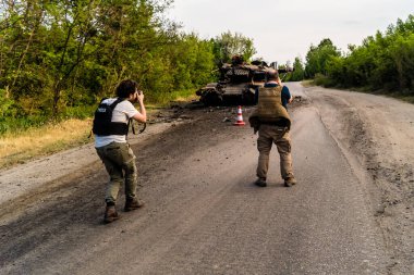 Kharkiv, Ukrayna Cephesi, 2 Haziran 2024 Joseph Roche ve Nicolas Cleuet, Kharkiv 'in kuzeyindeki Rus taarruzu sırasında imha edilen bir Rus saldırı tankını fotoğraflıyorlar.