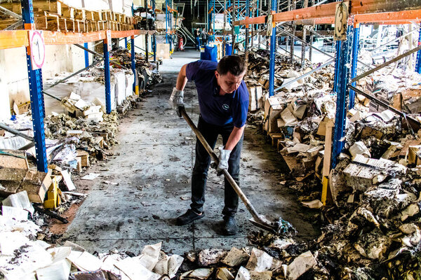 Харьков, Украина, 4 июня 2024 г. Сотрудник типографии "Фактор-Друк" приступает к уборке сожжённых книг после массированного ракетного обстрела 23 мая..