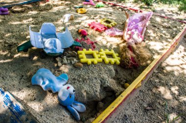 Kharkiv, Ukrayna, 19 Haziran 2024 Kharkiv 'in Saltivka ilçesindeki hasarlı bir binanın önünde terk edilmiş oyuncaklar. Rus ordusunun büyük saldırılarından sonra çocuklar buradan tahliye edildi.