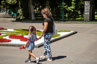 Kharkiv, Ukrayna, 21 Haziran 2024 Kharkiv sakinleri şehrin göbeğindeki Shevchenko Bahçesi 'nde yürüyorlar. Aileler ve insanlar Rusya' nın hava saldırısı riskine rağmen oraya yürümeye bayılıyorlar..