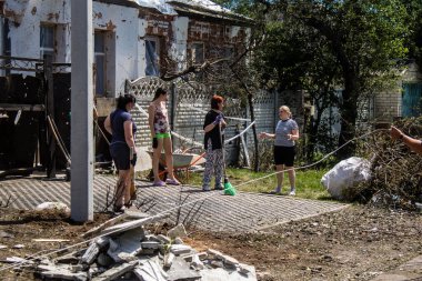 Derhachi, Ukrayna, 27 Haziran 2024 Derhachi kasabasındaki yıkılmış evlerin sakinleri Rus kuvvetlerinin güdümlü hava bombasıyla yaptığı saldırının ardından enkazı temizledi..