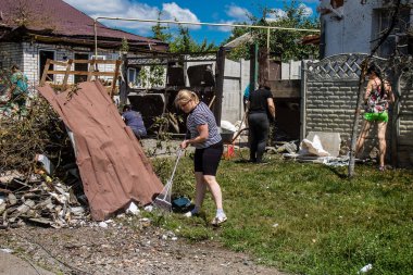 Derhachi, Ukrayna, 27 Haziran 2024 Derhachi kasabasındaki yıkılmış evlerin sakinleri Rus kuvvetlerinin güdümlü hava bombasıyla yaptığı saldırının ardından enkazı temizledi..