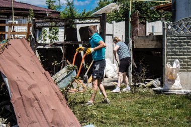 Derhachi, Ukrayna, 27 Haziran 2024 Derhachi kasabasındaki yıkılmış evlerin sakinleri Rus kuvvetlerinin güdümlü hava bombasıyla yaptığı saldırının ardından enkazı temizledi..