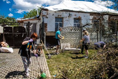 Derhachi, Ukrayna, 27 Haziran 2024 Derhachi kasabasındaki yıkılmış evlerin sakinleri Rus kuvvetlerinin güdümlü hava bombasıyla yaptığı saldırının ardından enkazı temizledi..