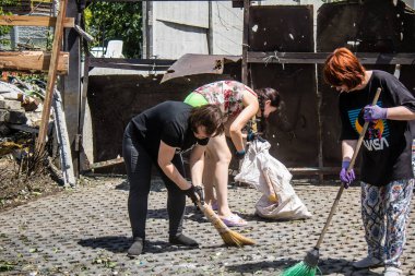 Derhachi, Ukrayna, 27 Haziran 2024 Derhachi kasabasındaki yıkılmış evlerin sakinleri Rus kuvvetlerinin güdümlü hava bombasıyla yaptığı saldırının ardından enkazı temizledi..