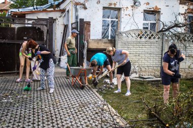 Derhachi, Ukrayna, 27 Haziran 2024 Derhachi kasabasındaki yıkılmış evlerin sakinleri Rus kuvvetlerinin güdümlü hava bombasıyla yaptığı saldırının ardından enkazı temizledi..