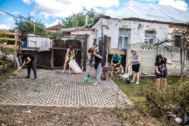 Derhachi, Ukrayna, 27 Haziran 2024 Derhachi kasabasındaki yıkılmış evlerin sakinleri Rus kuvvetlerinin güdümlü hava bombasıyla yaptığı saldırının ardından enkazı temizledi..