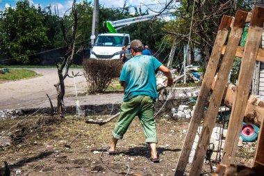 Derhachi, Ukrayna, 27 Haziran 2024 Derhachi kasabasındaki yıkılmış evlerin sakinleri Rus kuvvetlerinin güdümlü hava bombasıyla yaptığı saldırının ardından enkazı temizledi..