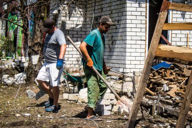 Derhachi, Ukrayna, 27 Haziran 2024 Derhachi kasabasındaki yıkılmış evlerin sakinleri Rus kuvvetlerinin güdümlü hava bombasıyla yaptığı saldırının ardından enkazı temizledi..