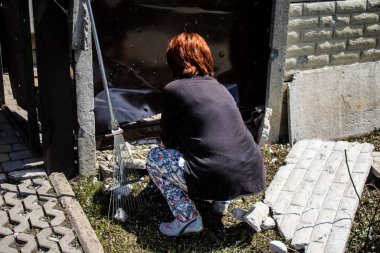 Derhachi, Ukrayna, 27 Haziran 2024 Derhachi kasabasındaki yıkılmış evlerin sakinleri Rus kuvvetlerinin güdümlü hava bombasıyla yaptığı saldırının ardından enkazı temizledi..