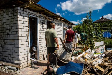 Derhachi, Ukrayna, 27 Haziran 2024 Derhachi kasabasındaki yıkılmış evlerin sakinleri Rus kuvvetlerinin güdümlü hava bombasıyla yaptığı saldırının ardından enkazı temizledi..