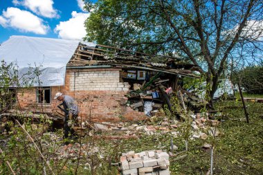 Derhachi, Ukrayna, 27 Haziran 2024 Derhachi kasabasındaki yıkılmış evlerin sakinleri Rus kuvvetlerinin güdümlü hava bombasıyla yaptığı saldırının ardından enkazı temizledi..