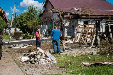 Derhachi, Ukrayna, 27 Haziran 2024 Derhachi kasabasındaki yıkılmış evlerin sakinleri Rus kuvvetlerinin güdümlü hava bombasıyla yaptığı saldırının ardından enkazı temizledi..