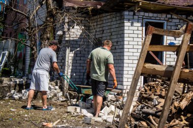 Derhachi, Ukrayna, 27 Haziran 2024 Derhachi kasabasındaki yıkılmış evlerin sakinleri Rus kuvvetlerinin güdümlü hava bombasıyla yaptığı saldırının ardından enkazı temizledi..
