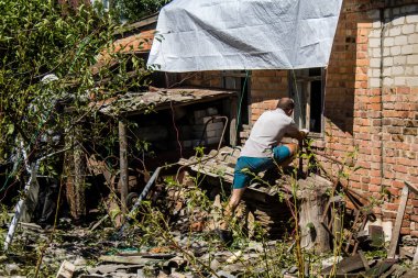 Derhachi, Ukrayna, 27 Haziran 2024 Derhachi kasabasındaki yıkılmış evlerin sakinleri Rus kuvvetlerinin güdümlü hava bombasıyla yaptığı saldırının ardından enkazı temizledi..