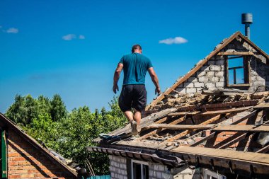 Tsyrkuny, Ukrayna, 29 Haziran 2024 İşçiler Tsyrkuny köyündeki yıkılmış evleri temizleyip onarıyor. Rus kuvvetleri Kharkiv Oblastı 'ndaki Tsyrkuny köyüne güdümlü hava bombasıyla saldırdılar..