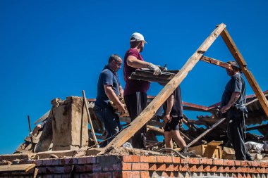 Tsyrkuny, Ukrayna, 29 Haziran 2024 İşçiler Tsyrkuny köyündeki yıkılmış evleri temizleyip onarıyor. Rus kuvvetleri Kharkiv Oblastı 'ndaki Tsyrkuny köyüne güdümlü hava bombasıyla saldırdılar..