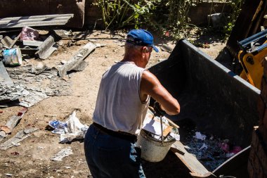 Tsyrkuny, Ukrayna, 29 Haziran 2024 İşçiler Tsyrkuny köyündeki yıkılmış evleri temizleyip onarıyor. Rus kuvvetleri Kharkiv Oblastı 'ndaki Tsyrkuny köyüne güdümlü hava bombasıyla saldırdılar..